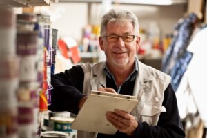 een wat oudere man met een clipboard in zijn handen dit is voor de Vacature bouwmarkt medewerker